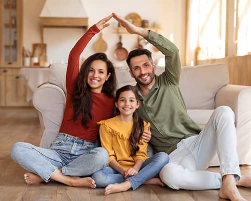 Happy family making home shape with hands in their new house in Florida